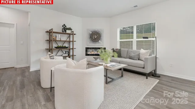 a living room with furniture wooden floor and a large window