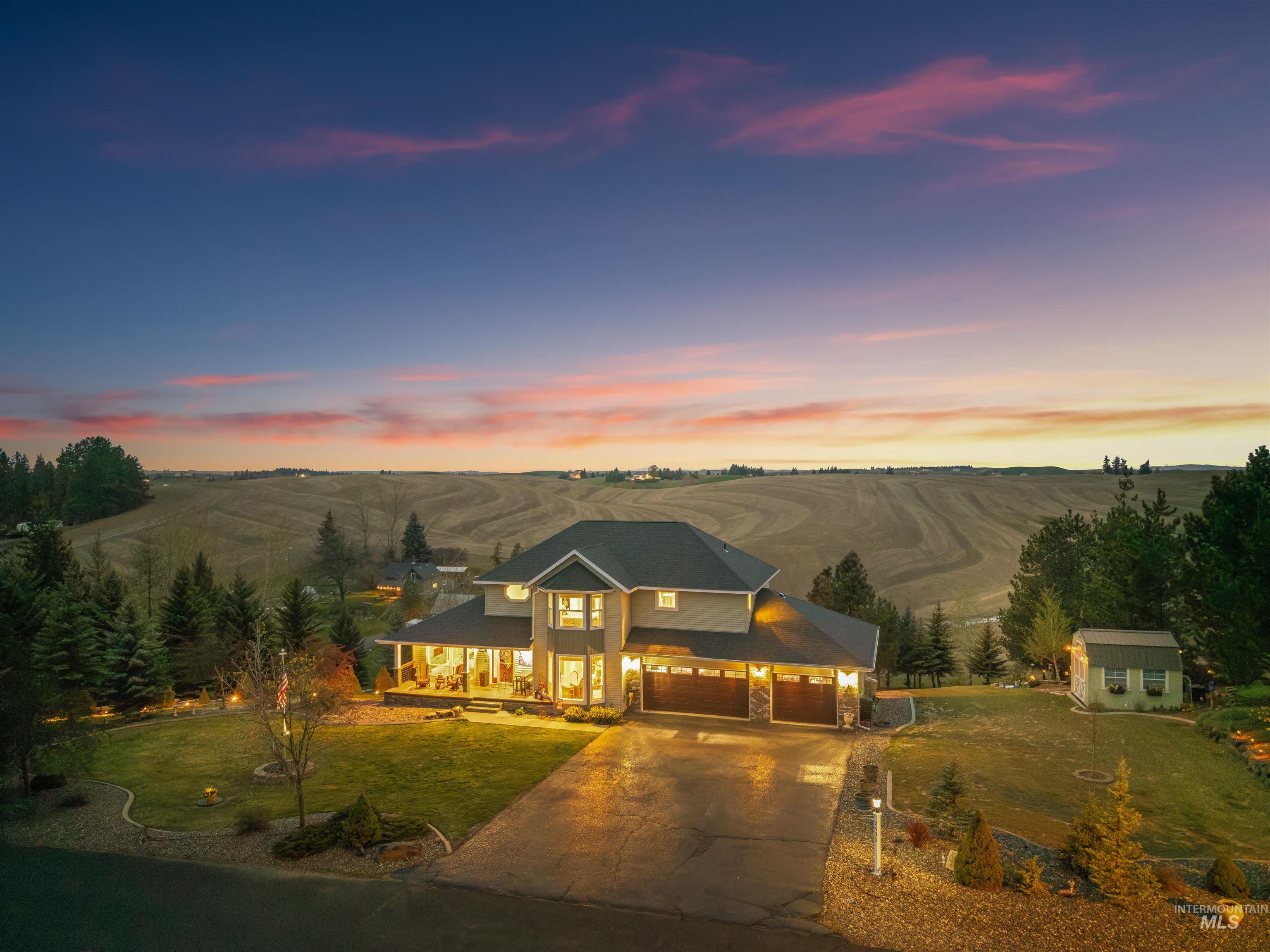 2435 Arborcrest Road Moscow, ID 83843 - Photo 47 of 50 View of front facade with a lawn, concrete driveway, a rural view, and a garage