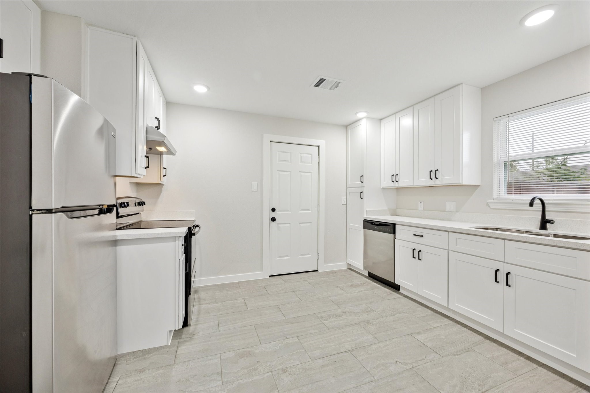 6731 London Street Houston, TX 77021 - Photo 5 of 11 a kitchen with a sink a refrigerator and cabinets