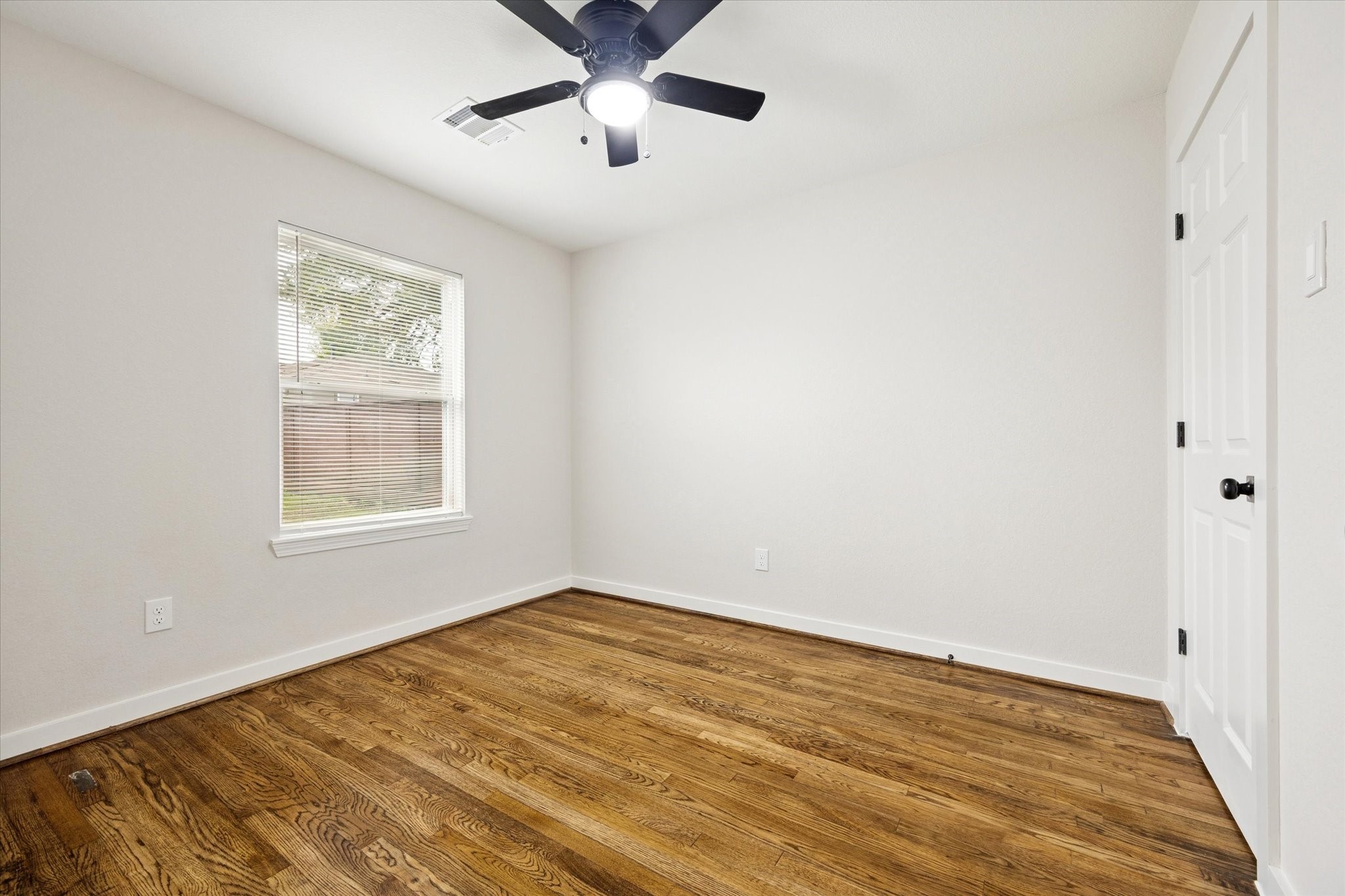 6731 London Street Houston, TX 77021 - Photo 7 of 11 a view of an empty room with a window and wooden floor