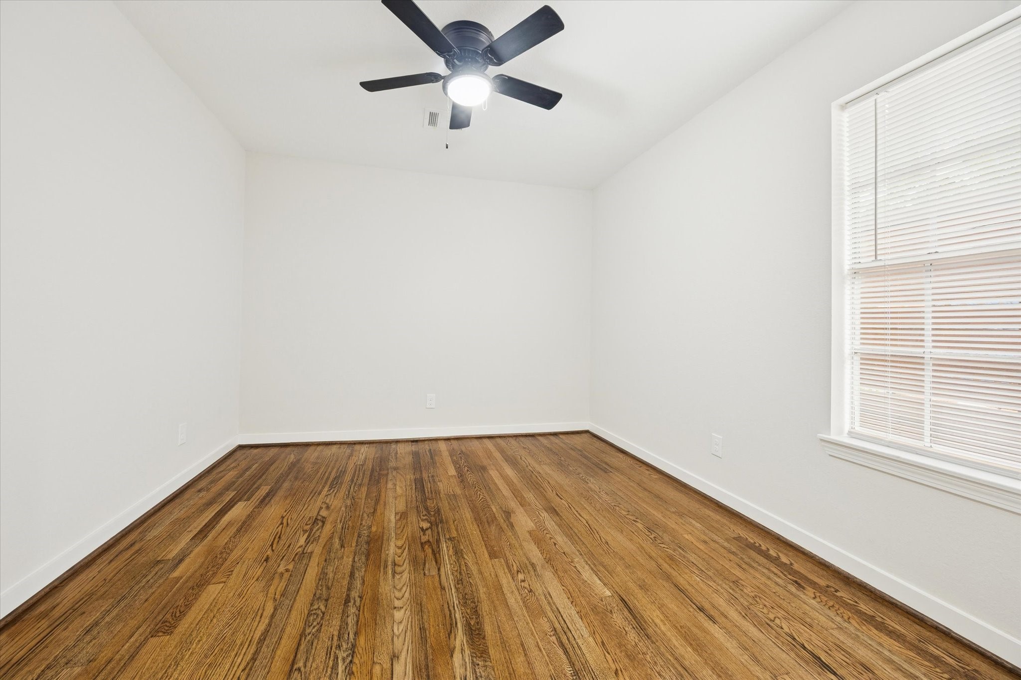 6731 London Street Houston, TX 77021 - Photo 8 of 11 an empty room with wooden floor cabinet and windows