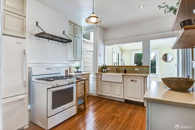 a kitchen with white cabinets and white appliances
