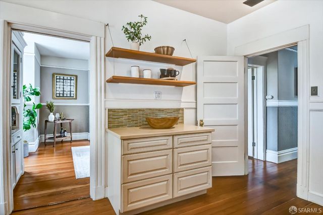 a hallway with a dresser and a potted plant