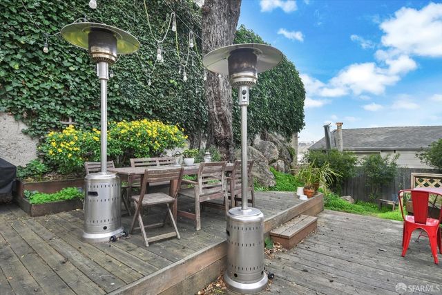 a view of a chair and table in backyard of the house