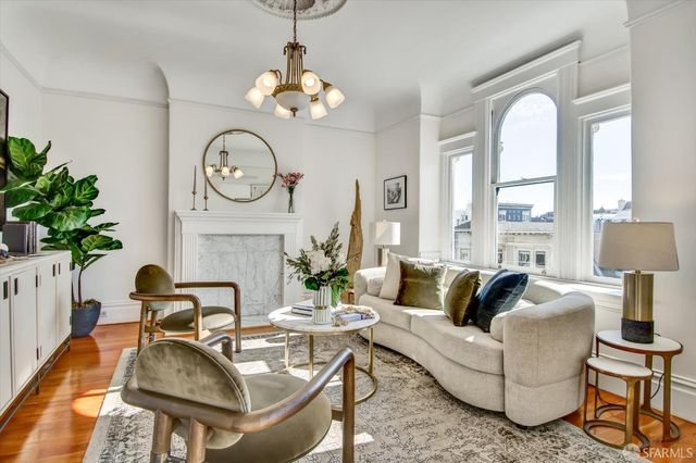 a living room with fireplace furniture and a large window