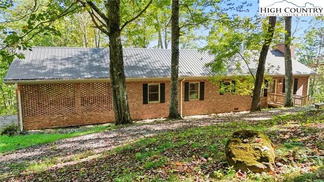 a view of a house with a yard and large tree