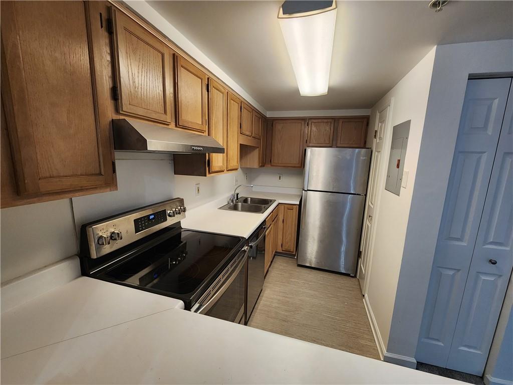 a kitchen with a refrigerator and a stove top oven
