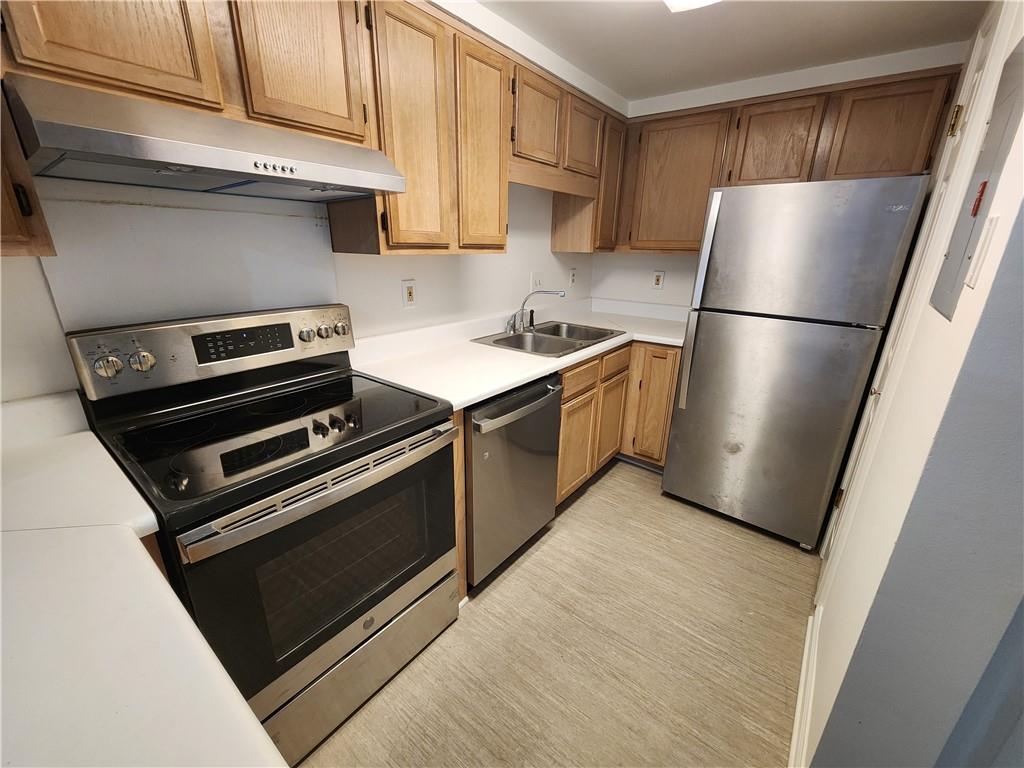 199 14th Street Northeast, Unit 209 Atlanta, GA 30309 - Photo 5 of 13 a kitchen with wooden cabinets and stainless steel appliances