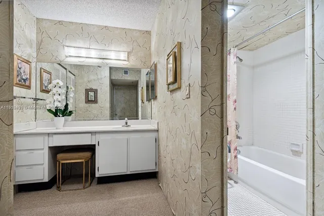 a bathroom with a double vanity sink a mirror a bathtub and shower