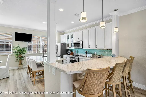 a kitchen with stainless steel appliances granite countertop a kitchen island a stove a table and chairs