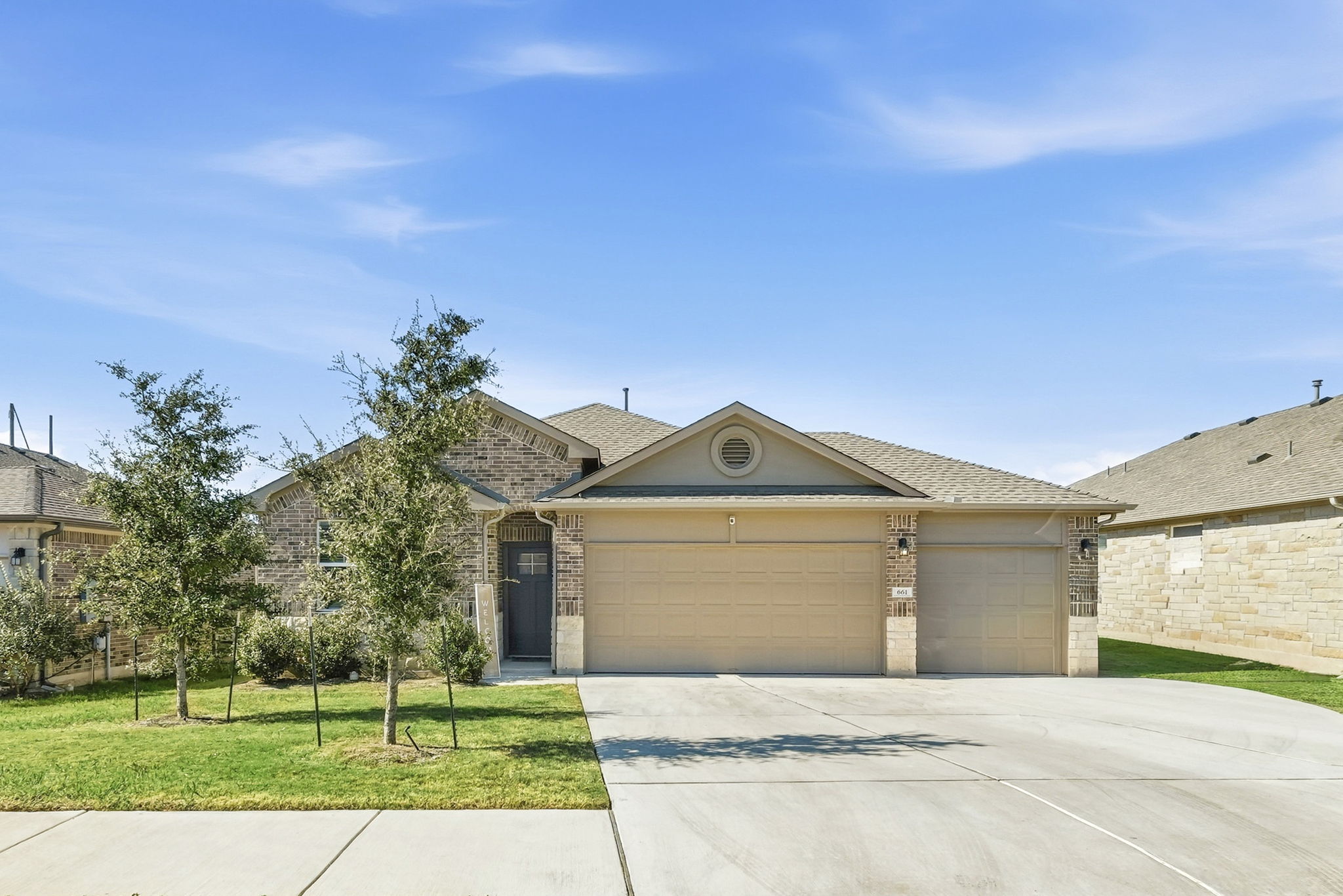 a front view of a house with a garden and yard