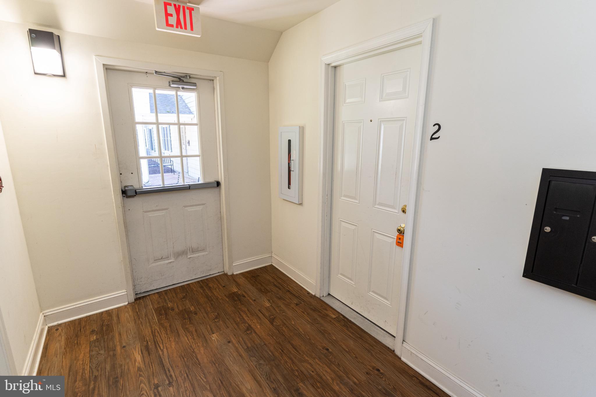 804 Travers Street, Unit 2 Cambridge, MD 21613 - Photo 2 of 26 an empty room with wooden floor and windows