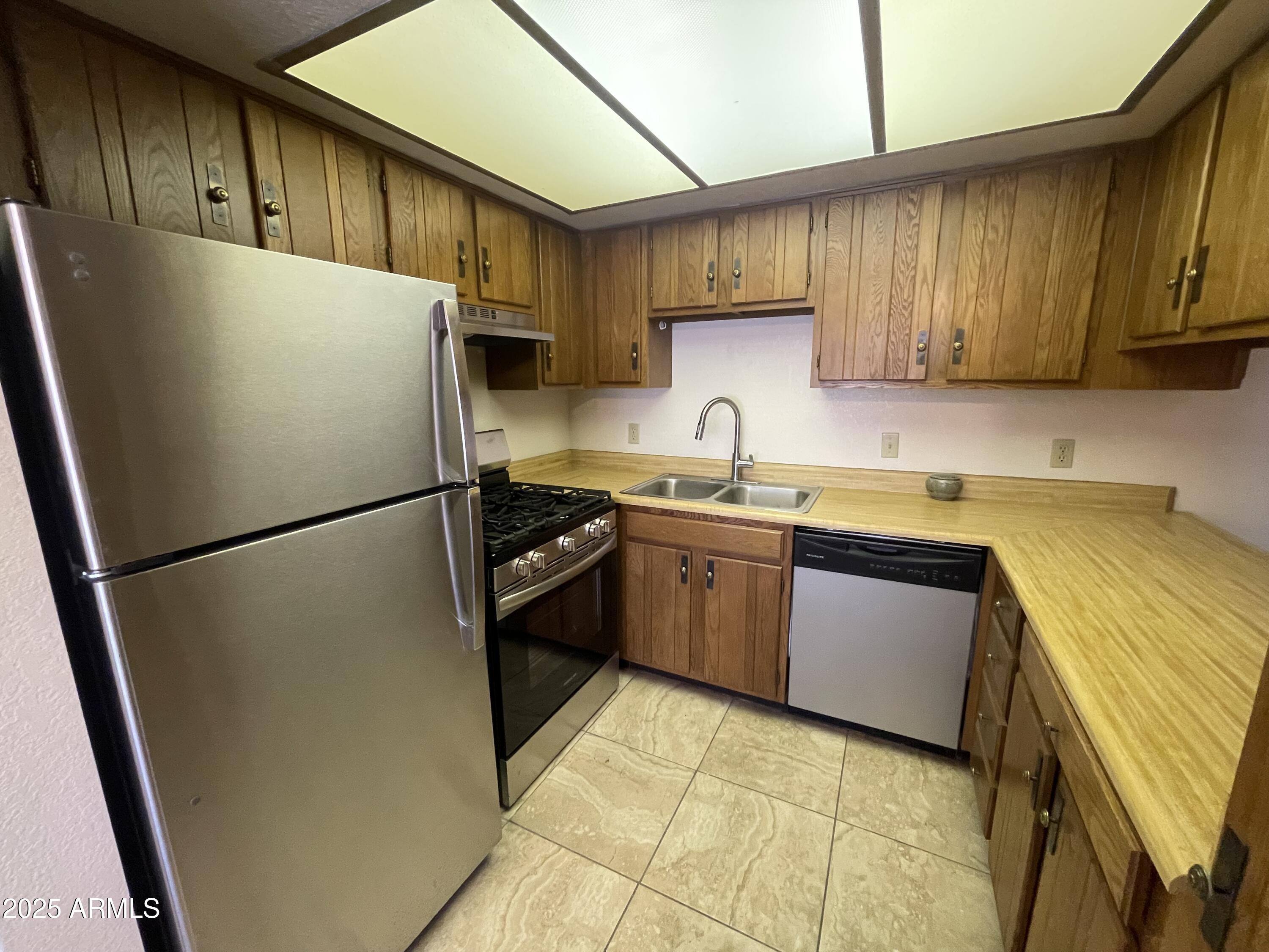 827 East Lancaster Circle Florence, AZ 85132 - Photo 4 of 24 a kitchen with a refrigerator sink and cabinets