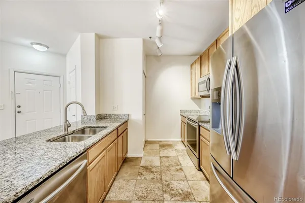 a kitchen with granite countertop a sink a counter space and cabinets