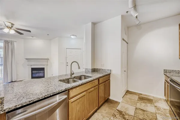 a kitchen with stainless steel appliances granite countertop a refrigerator sink and stove