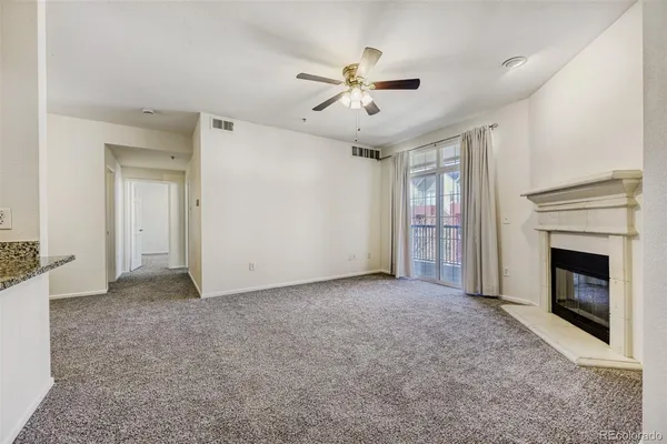 a living room with fireplace furniture and a kitchen view