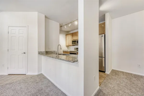 a kitchen with stainless steel appliances granite countertop a sink and a refrigerator
