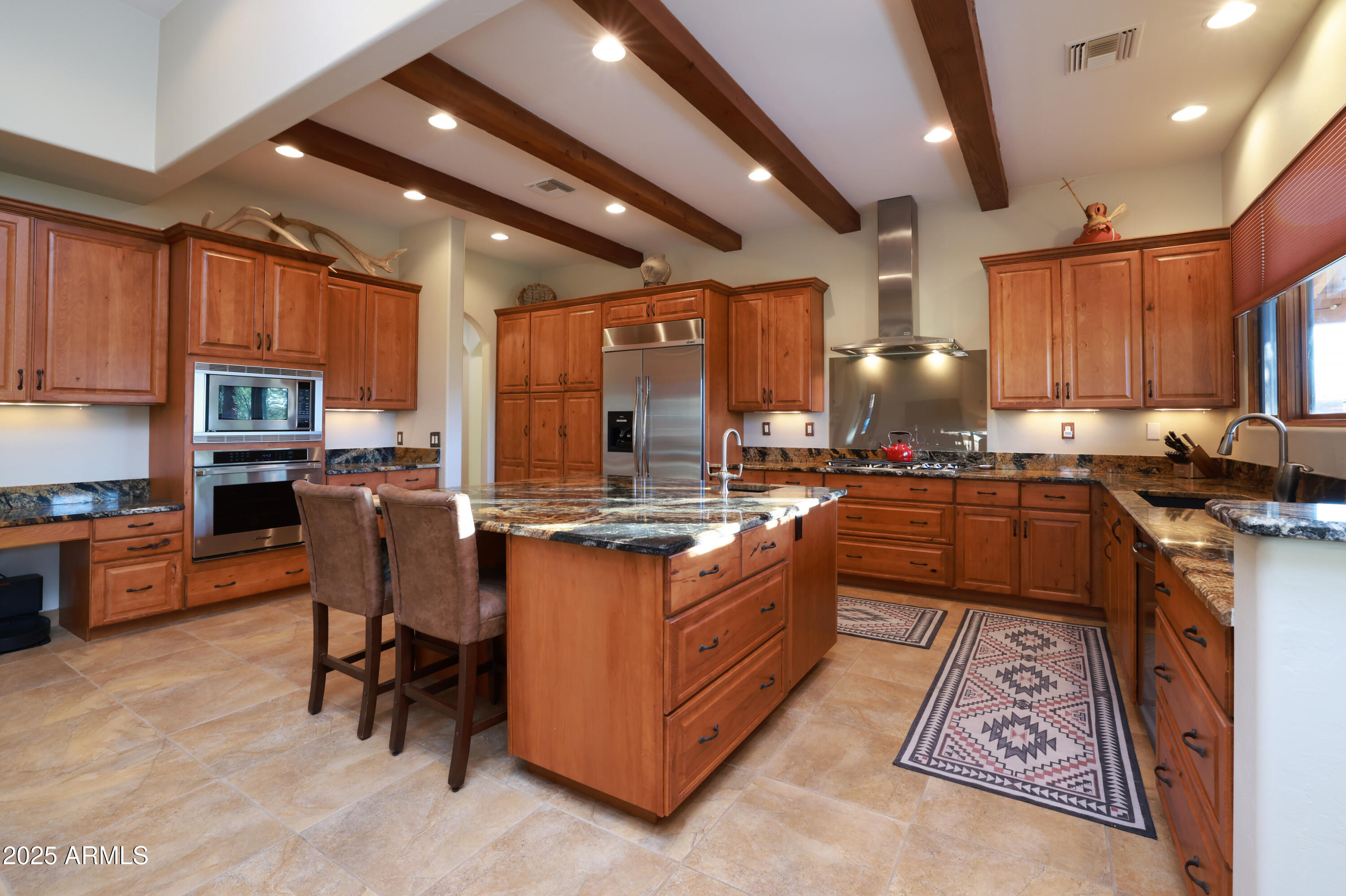 12800 West Arivaca Road Amado, AZ 85645 - Photo 12 of 48 a kitchen with stainless steel appliances granite countertop a stove top oven a sink dishwasher a dining table and chairs with wooden floor