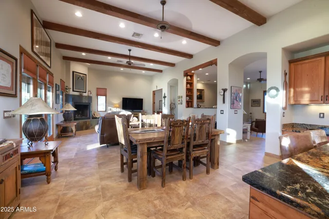 a living room with furniture kitchen view and a wooden floor