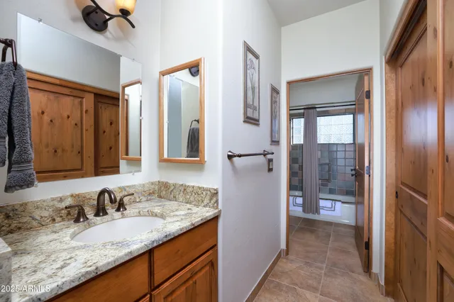 a bathroom with a granite countertop sink and a mirror
