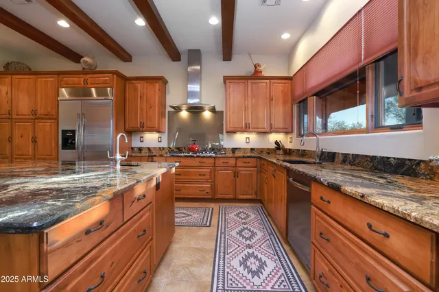a large kitchen with stainless steel appliances wooden cabinets and a counter top space