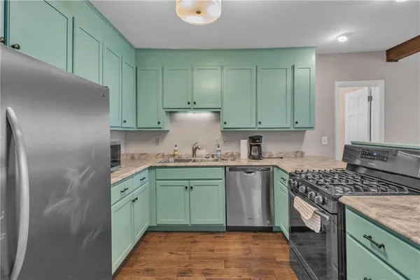 a kitchen with kitchen island granite countertop a sink a stove and refrigerator