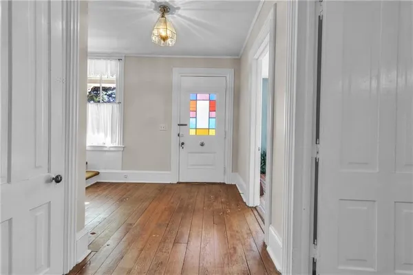a view of a hallway with wooden floor and closet area