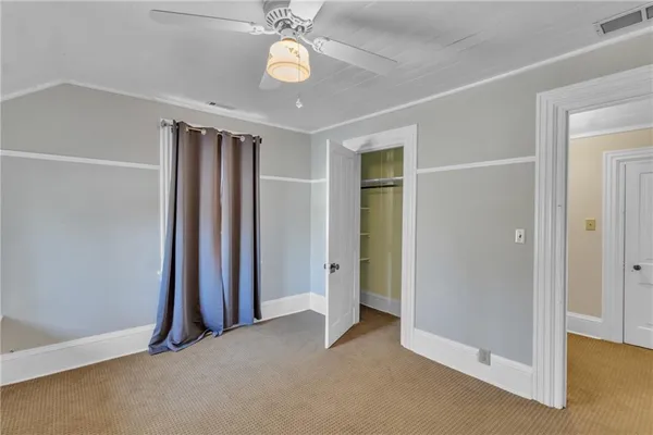 an empty room with closet and windows