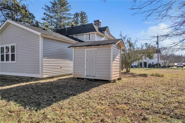 a front view of a house with yard tree and wooden fence