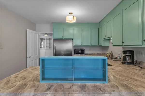 a kitchen with cabinets and a refrigerator