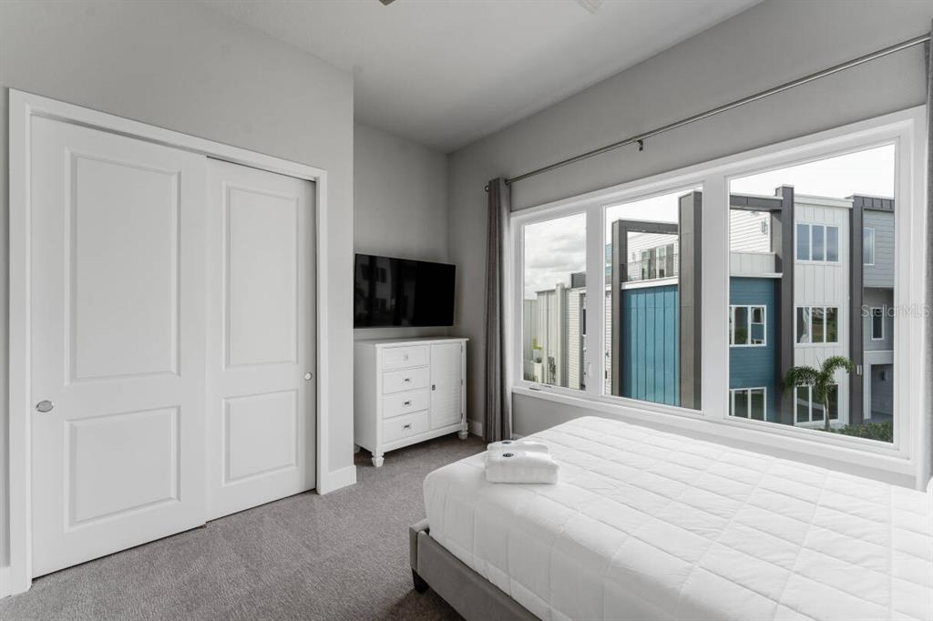 7760 Sandy Ridge Drive, Unit 226 Reunion, FL 34747 - Photo 21 of 40 a bedroom with a bed and a flat tv screen