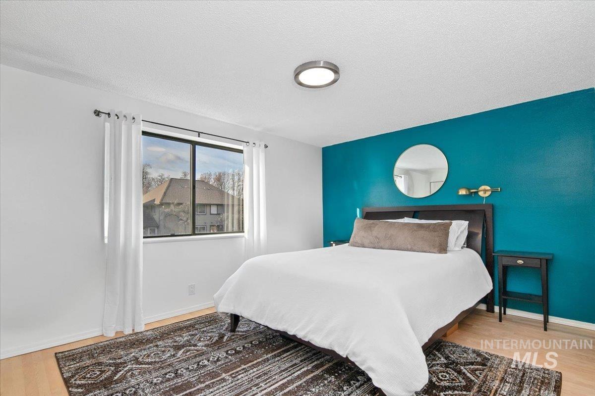 3651 South Gekeler Lane, Unit 96 Boise, ID 83706 - Photo 13 of 38 Bedroom featuring light wood finished floors and a textured ceiling