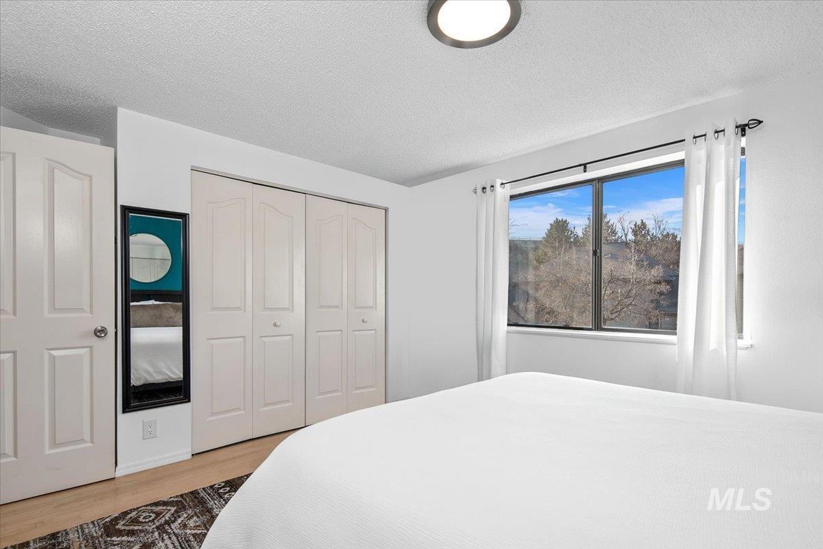 3651 South Gekeler Lane, Unit 96 Boise, ID 83706 - Photo 16 of 38 Bedroom featuring a textured ceiling, a closet, and wood finished floors