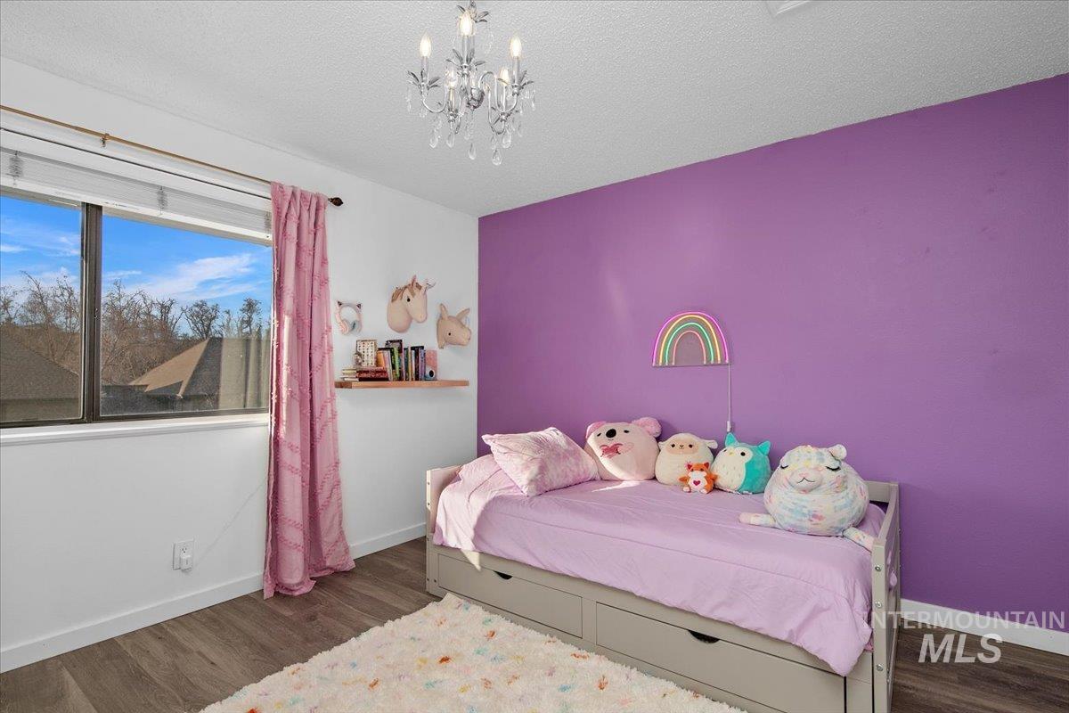 3651 South Gekeler Lane, Unit 96 Boise, ID 83706 - Photo 28 of 38 Bedroom with a chandelier, dark wood-style flooring, and a textured ceiling
