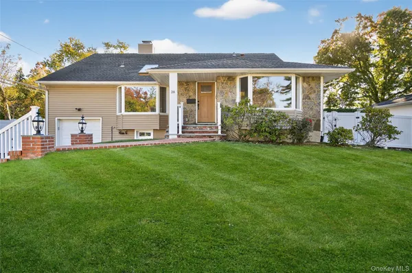 a front view of a house with a yard and trees