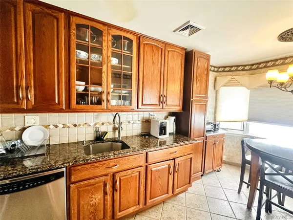 a kitchen with stainless steel appliances granite countertop a sink and a stove next to a window