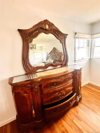 a room with a mirror and wooden floor