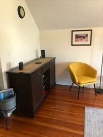 a living room with a table chairs and a wooden floor