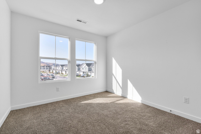 788 West 2840 South, Unit 2 Logan, UT 84321 - Photo 13 of 21 Room featuring two large windows, white walls, and neutral-toned carpet flooring