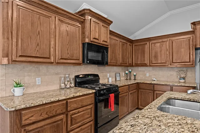 a kitchen with stainless steel appliances granite countertop a sink stove and cabinets