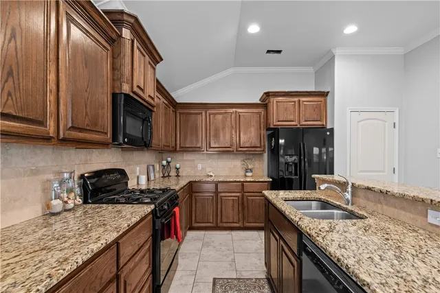 a kitchen with stainless steel appliances granite countertop a sink stove and cabinets