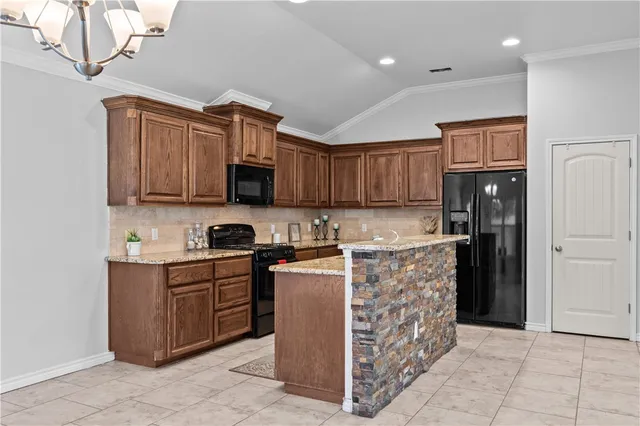 a kitchen with stainless steel appliances granite countertop a stove top oven a refrigerator and a sink