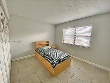 9440 Southwest 8th Street, Unit 202 Boca Raton, FL 33428 - Photo 7 of 20 a bedroom with a bed and a window