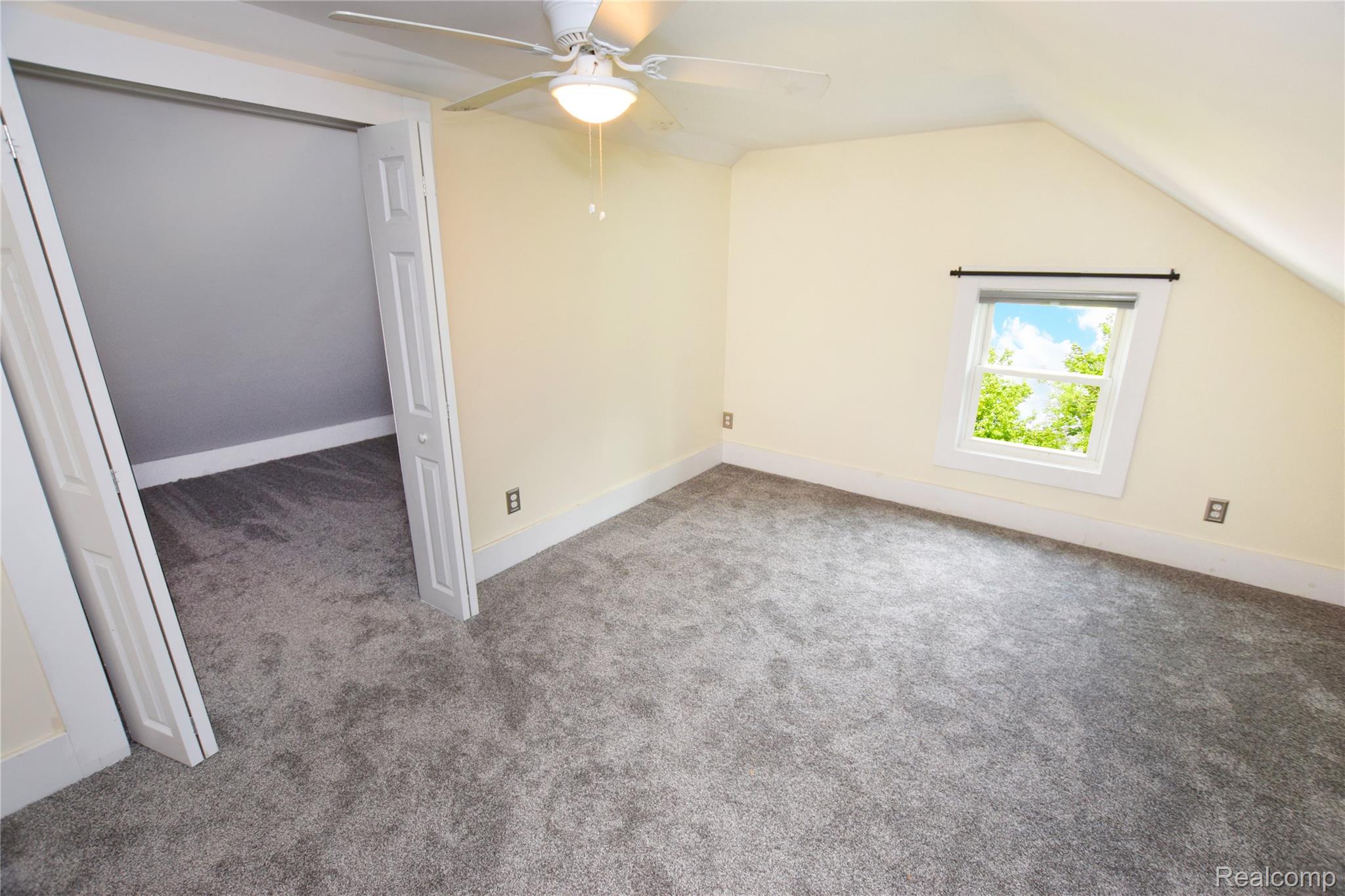 404 North Adelaide Street Fenton, MI 48430 - Photo 15 of 23 Carpeted room featuring a ceiling fan, a window with natural light, and a white trim baseboard