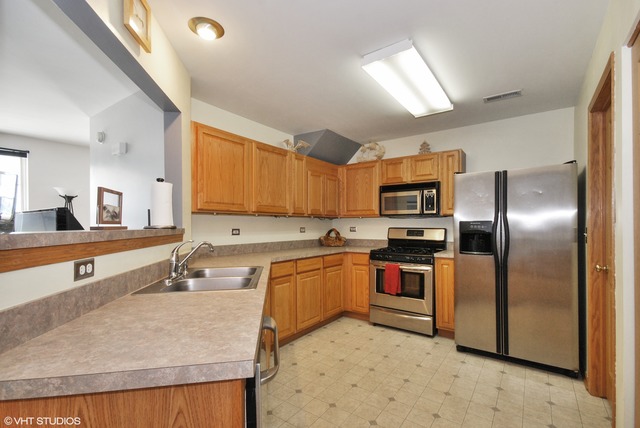 1734 Windcrest Lane Aurora, IL 60504 - Photo 4 of 10 a large kitchen with stainless steel appliances granite countertop a sink a stove and a refrigerator
