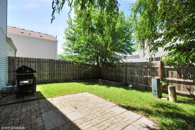 1734 Windcrest Lane Aurora, IL 60504 - Photo 10 of 10 a view of a backyard with plants and wooden fence