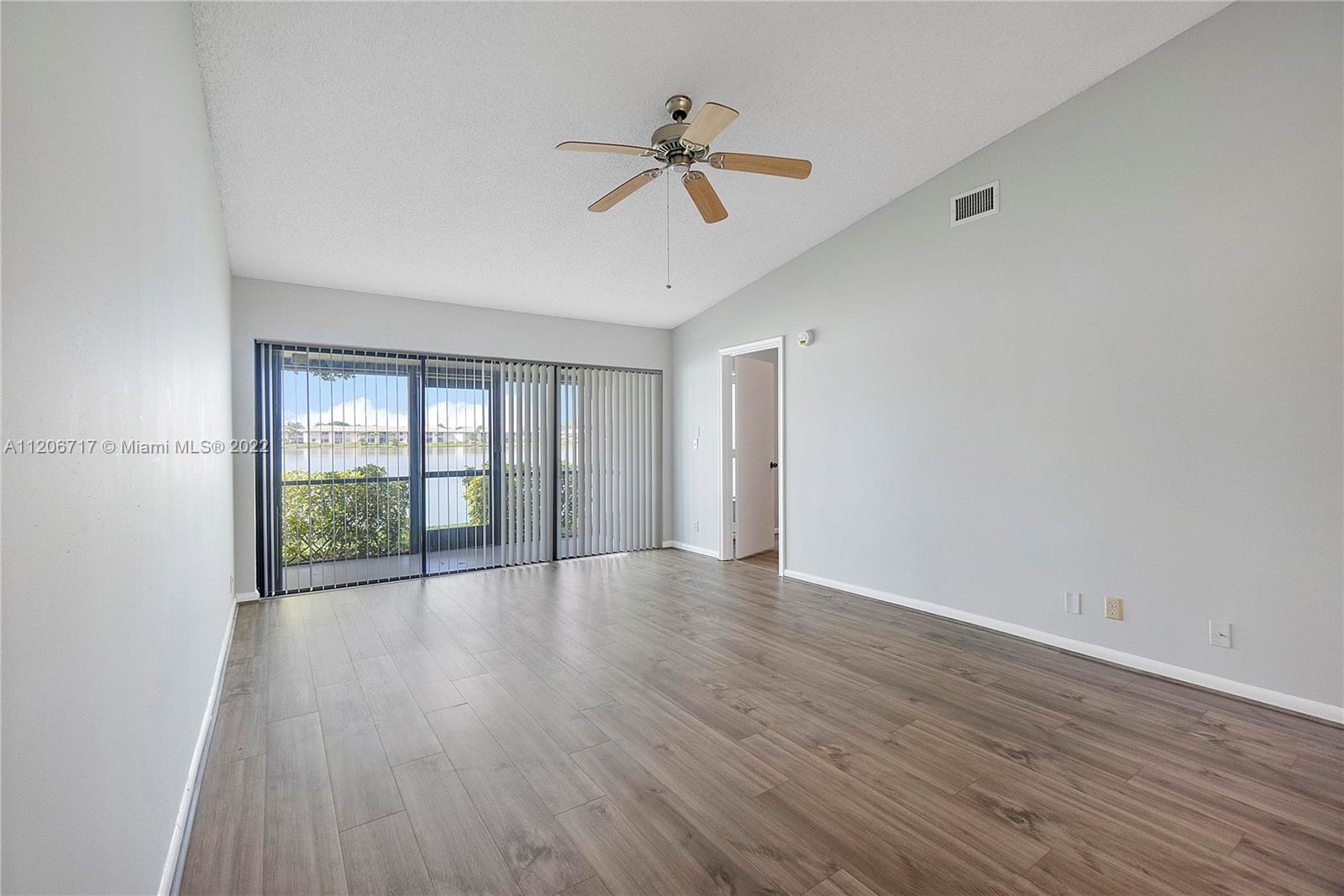 633 Banks Road, Unit 633 Margate, FL 33063 - Photo 12 of 48 a view of an empty room with wooden floor and a window