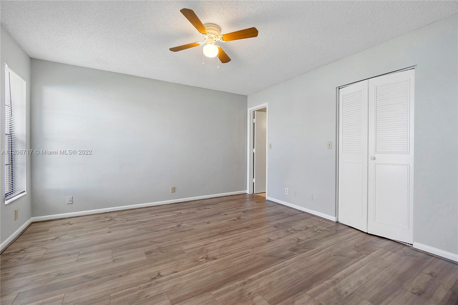 633 Banks Road, Unit 633 Margate, FL 33063 - Photo 16 of 48 an empty room with wooden floor and a ceiling fan
