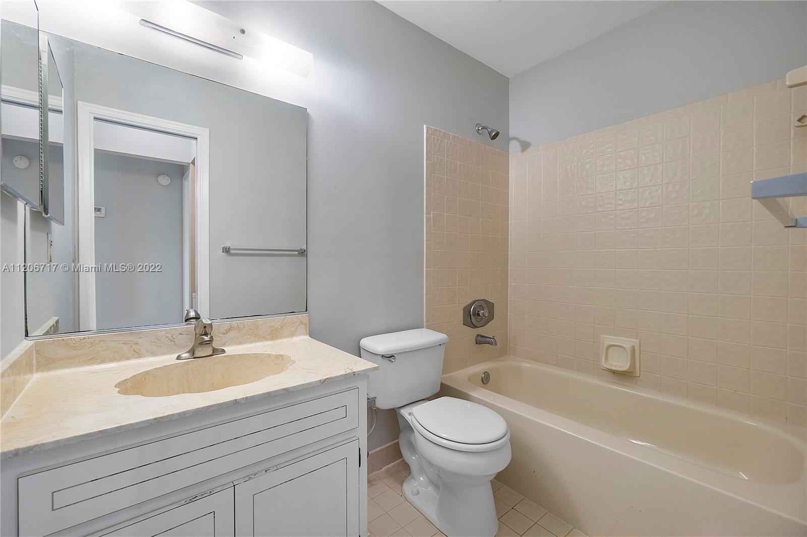 633 Banks Road, Unit 633 Margate, FL 33063 - Photo 24 of 48 a bathroom with a sink a toilet and a mirror