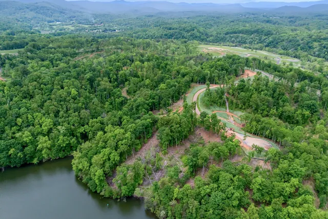an aerial view of a house with a yard and street